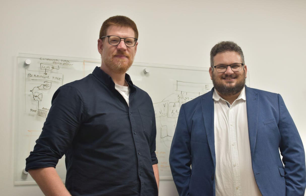 Kinematic Trees co-founders Stuart Wilson and Daniel Camilleri standing in front of a whiteboard